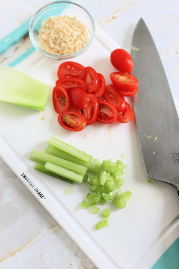 chopping celery and tomato for tuna melt sandwiches
