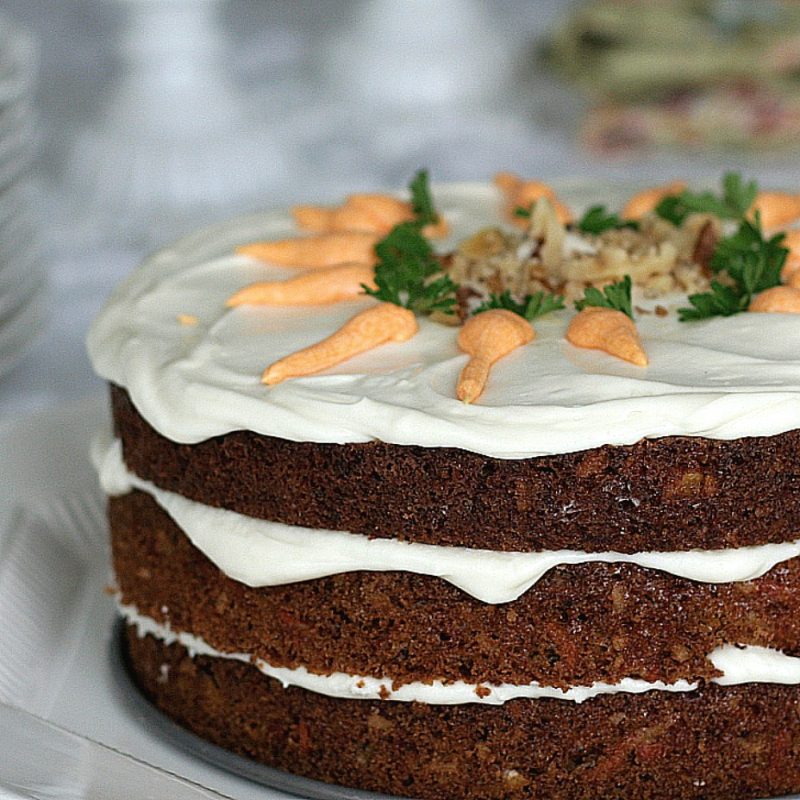 Classic three-layer carrot cake with cream cheese frosting is incredibly moist and delicious! Flecks of carrot, nuts and lightly spiced with cinnamon.