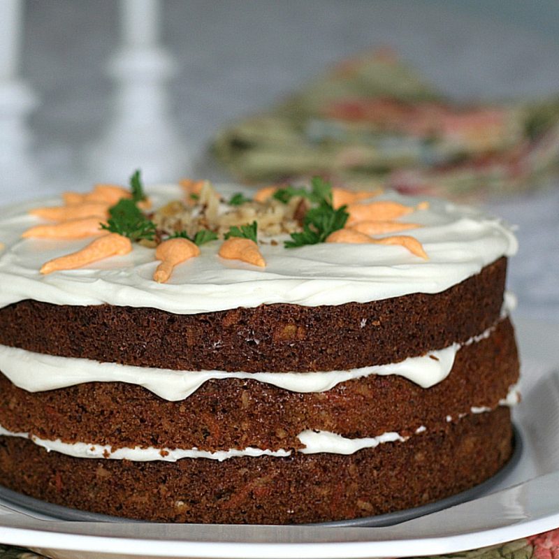 Classic three-layer carrot cake with cream cheese frosting is incredibly moist and delicious! Flecks of carrot, nuts and lightly spiced with cinnamon.