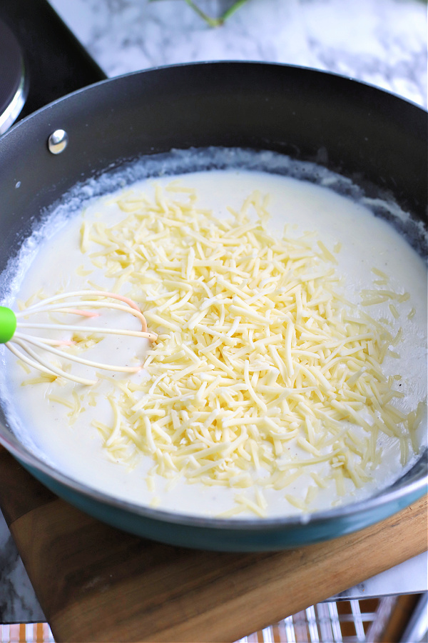 adding cheddar cheese to roux for homemade baked macaroni and cheese
