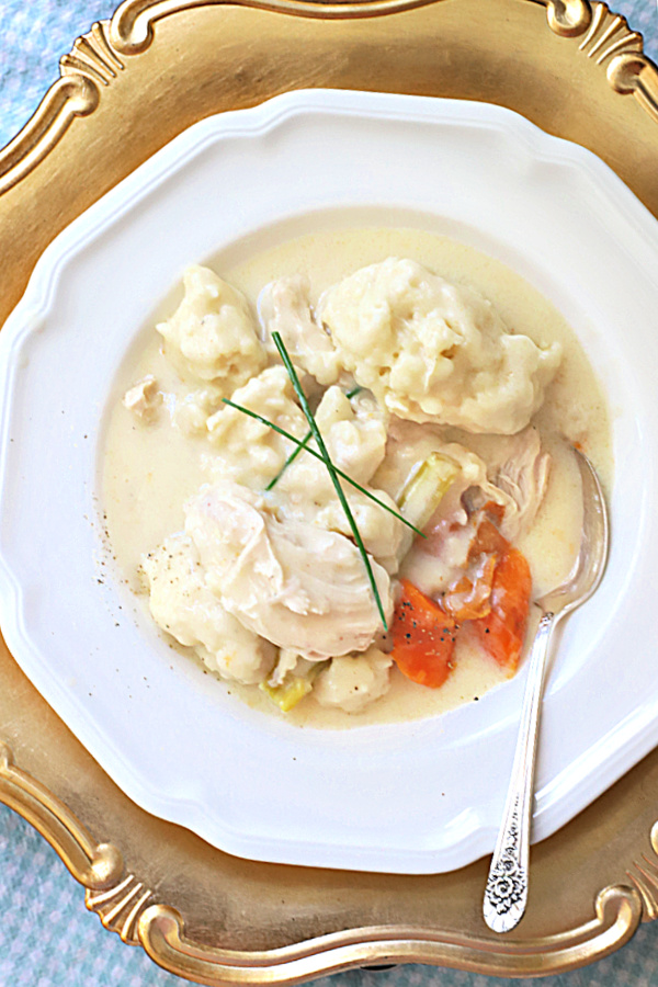 Homemade chicken & dumplings, a classic comfort food or tender stewed chicken in a creamy gravy topped with fluffy dumplings. An easy recipe for an old fashioned dinner.