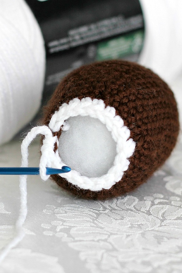 Peek inside this sweet crocheted chocolate diorama Easter egg decorated with faux frosting and embroidered scrolls. Cute pattern for holiday décor tablescapes or filling Easter baskets.