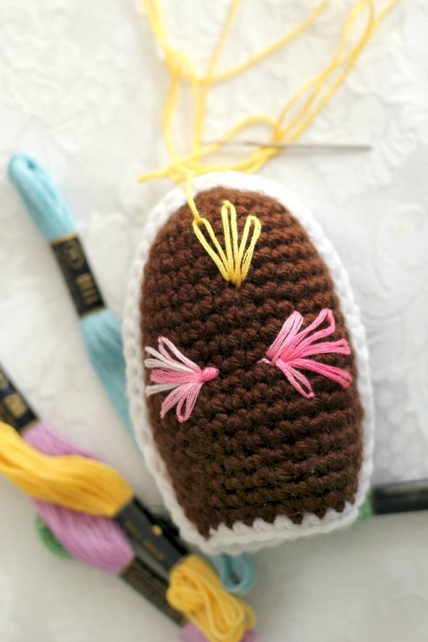Super cute pattern for chocolate diorama Easter egg is crocheted with faux frosting and embroidered decorations. Sweet holiday décor for tablescape or Easter baskets.