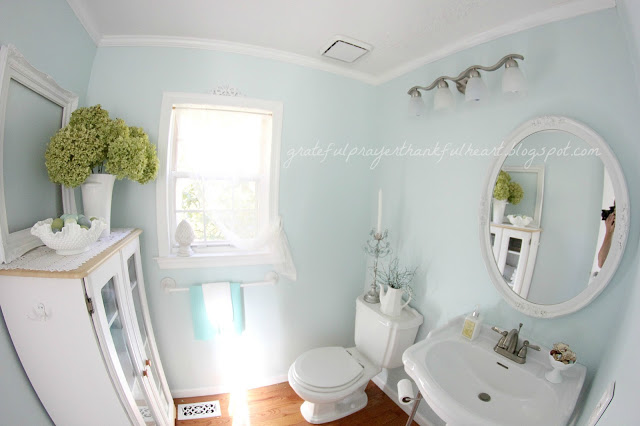 Easy DIY Powder Room redo in Aqua frost paint color with pretty white accents found around the house and re-purposed to create a lovely room on a budget.