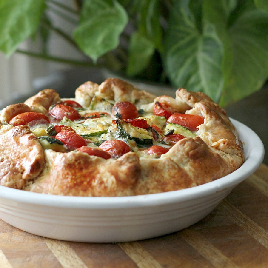 Cheesy Tomato Zucchini Galette with a filling of fresh tomatoes, mozzarella, Parmesan basil and zucchini in a thick crust. Serve as an appetizer or dinner entrée.