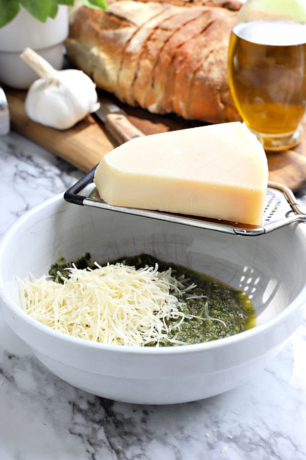Adding Parmesan cheese to fresh basil pesto 