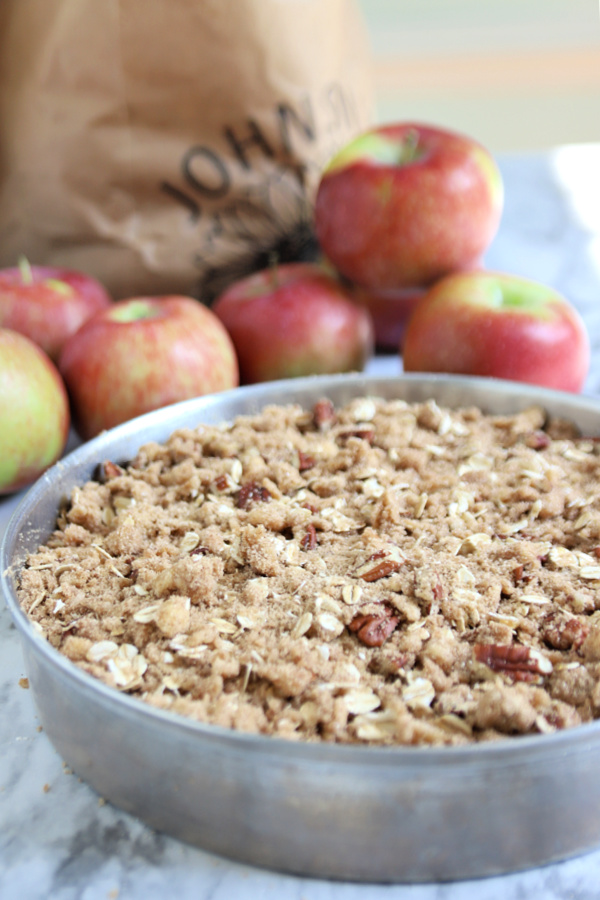 adding the crumb topping to the apple coffee cake batter