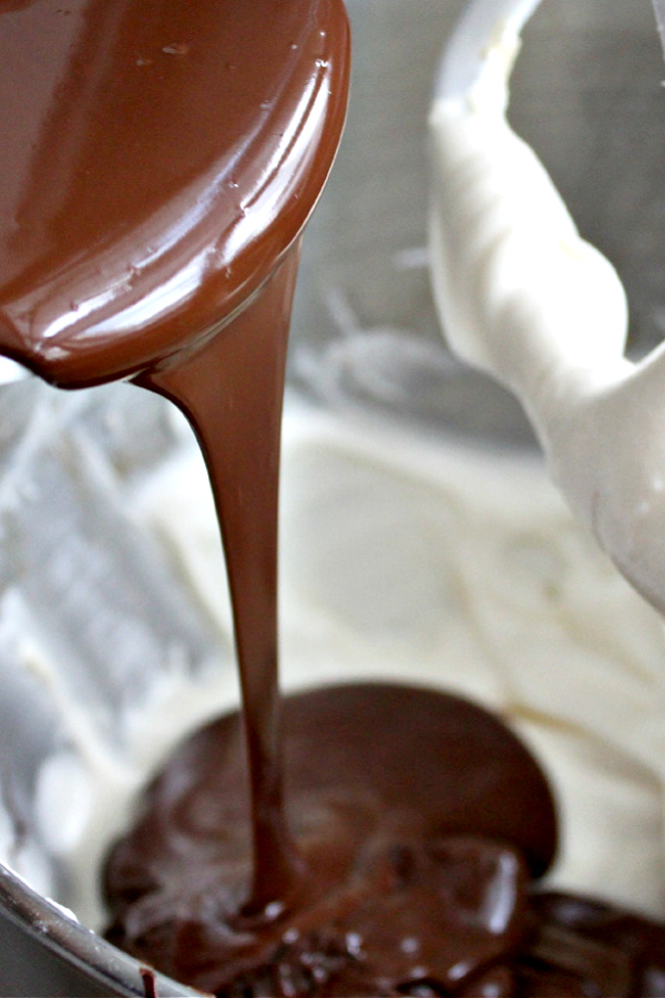 Combining cream cheese mixture with melted chocolate for truffles.