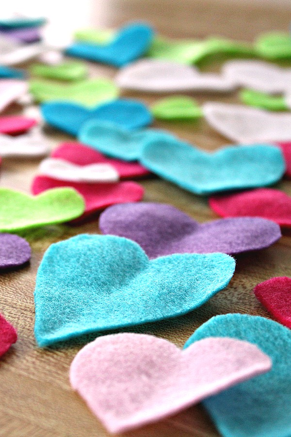 Easy Valentine's Day garland made by sewing felt hearts together. Hang hearts overflowing garland on the mantle, a window or wherever happy hearts are wanted.