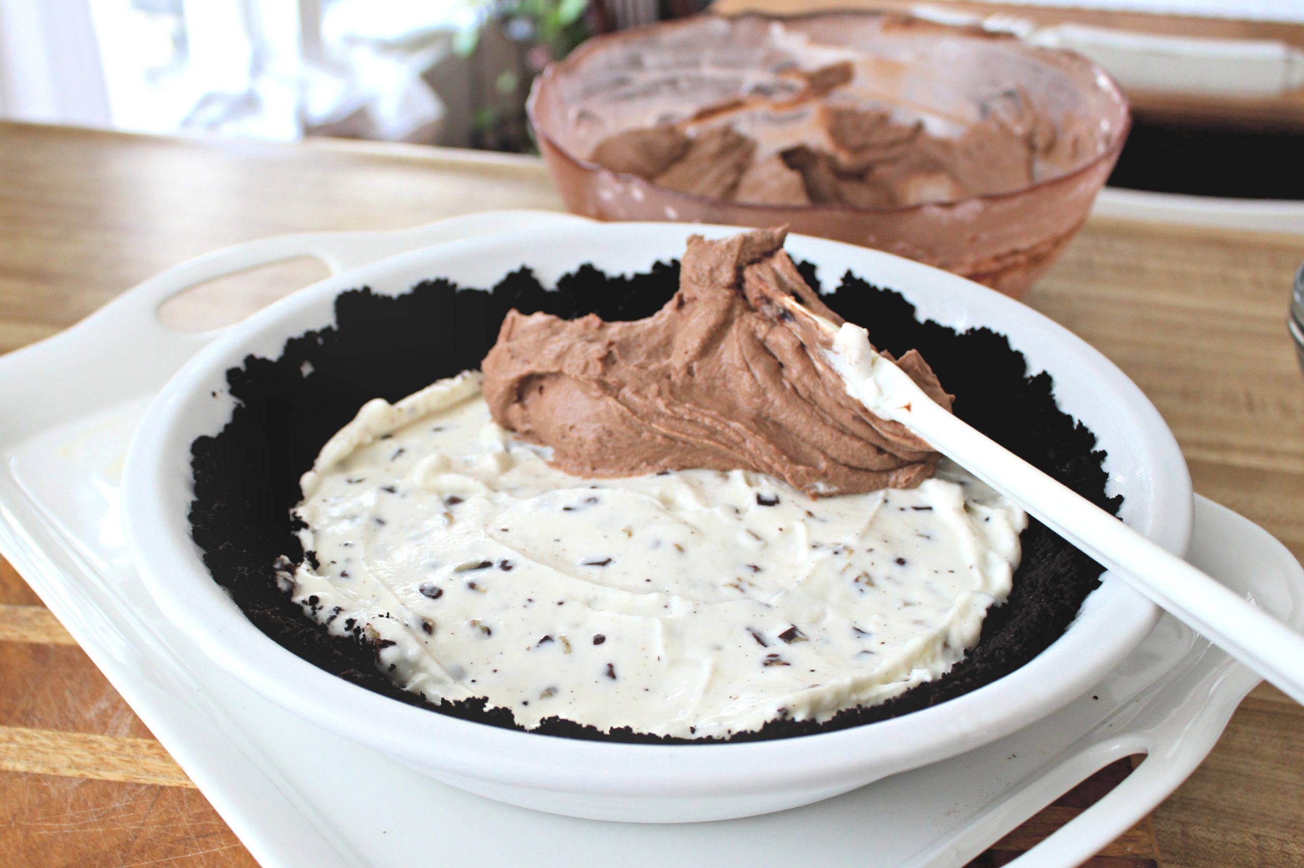 Easy recipe for frozen minty mousse pie with a layers of ice cream, chocolate mousse and whipped cream in a cookie crust is just right for St Patrick's Day