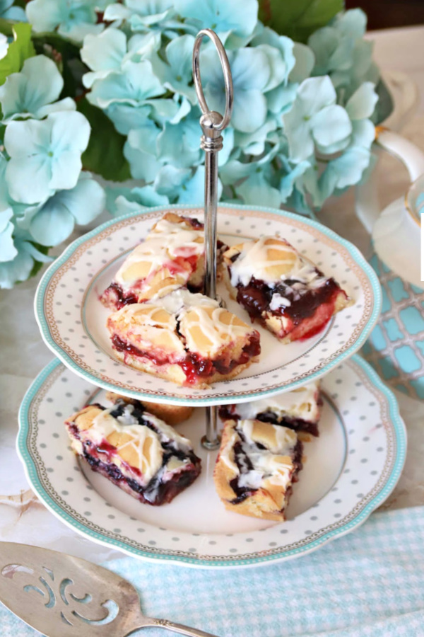 Easy recipe for homemade fruit bars baked in a sheet pan and drizzled with frosting using cherry and/or blueberry pie filling.