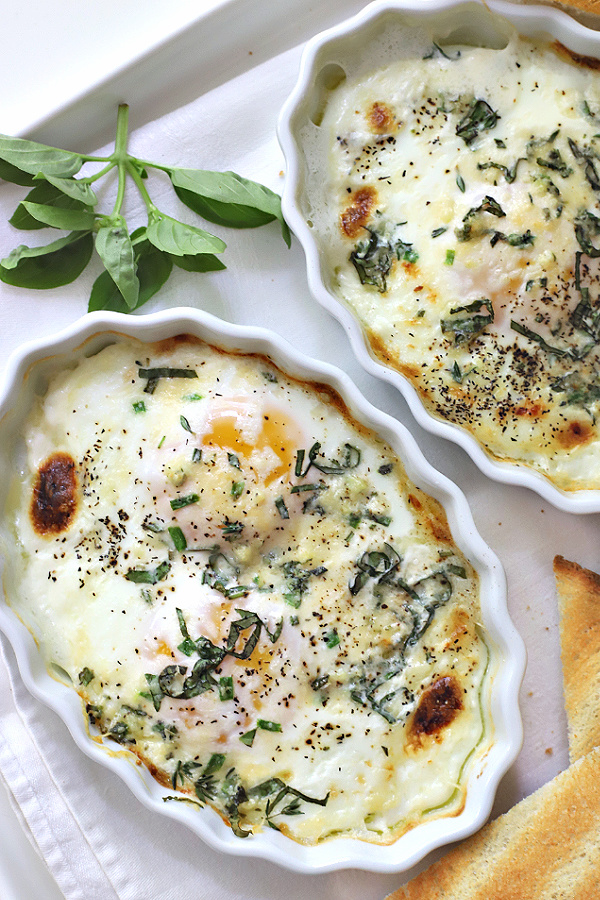 Easy recipe for making baked eggs with fresh herbs and Parmesan cheese in the oven.