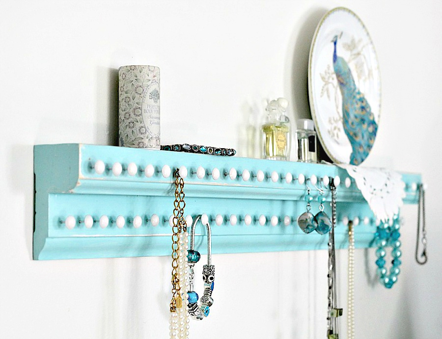 Easy DIY project for keeping jewelry organized and from tangling. Wooden wall shelf has plenty of hooks to keep necklaces and bracelets neat and within easy reach. 