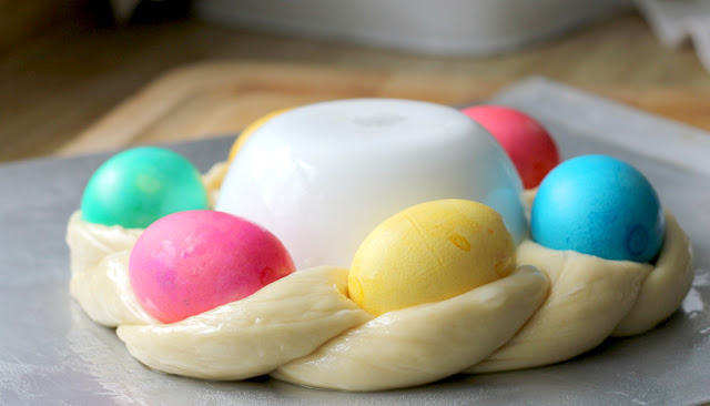 A beautiful Easter egg braided yeast bread tastes delicious and is so pretty with dyed eggs tucked into the braided ring then drizzled with a light glaze. Easy recipe using a bread machine to make the dough.
