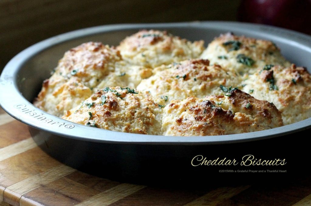 Easy recipe for homemade buttermilk cheddar cheese biscuits brushed with herb butter. Drop scoops of dough into pan and bake. No kneading or cutting involved.