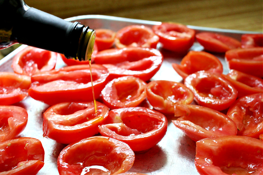Adding olive oil to Roma tomatoes for roasted tomato Capresse salad