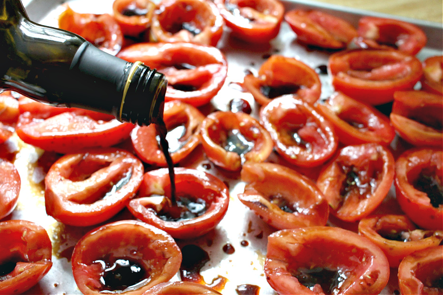 Adding balsamic vinegar to Roma tomatoes for roasted tomato Capresse salad