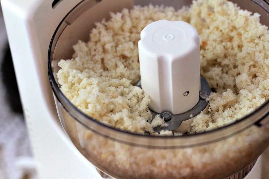 Using a food processor to prepare breadcrumbs for classic crab cakes recipe.