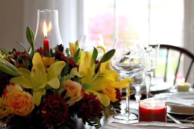Flowers add a festive touch to your Thanksgiving table. Lovely autumn colors with a hurricane globe & candles creates an elegant tablescape. 