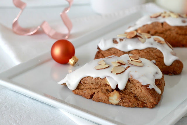 Toasted almond gingerbread scones are frosted and topped with a sprinkling of almonds. Delicious and festive holiday flavor for breakfast or coffee break.