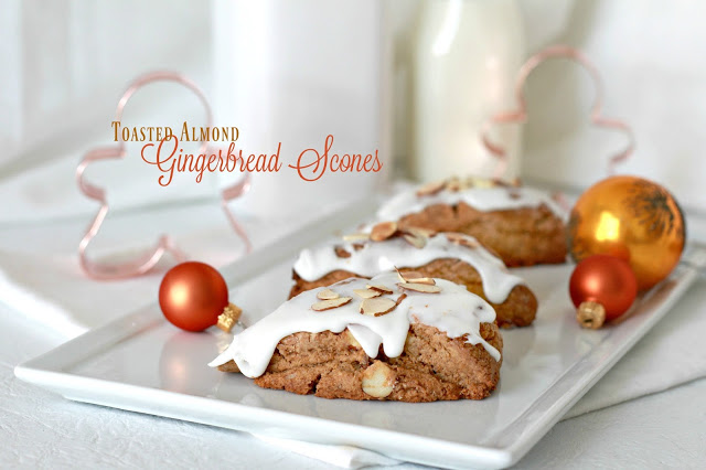 Toasted almond gingerbread scones are frosted and topped with a sprinkling of almonds. Delicious and festive holiday flavor for breakfast or coffee break.