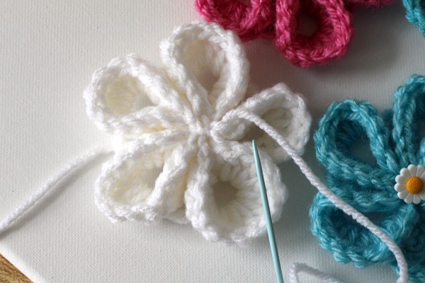 Pretty crochet flowers for all kinds of projects. Wall art or embellishing hats, beanies and bags. Easy to follow video tutorial.