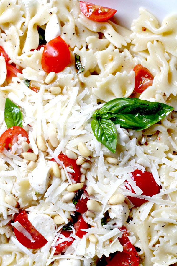 Easy recipe for Caprese Bow Tie Pasta Salad served cold with fresh mozzarella cheese, tomatoes and basil. Perfect for summertime dining.