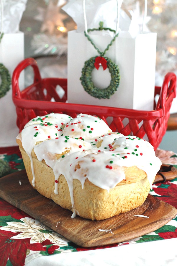 Bake a festive loaf of rich holiday brioche from easy recipe using a bread machine. Frosted with a white glaze and colorful sprinkles. Great food gift idea.
