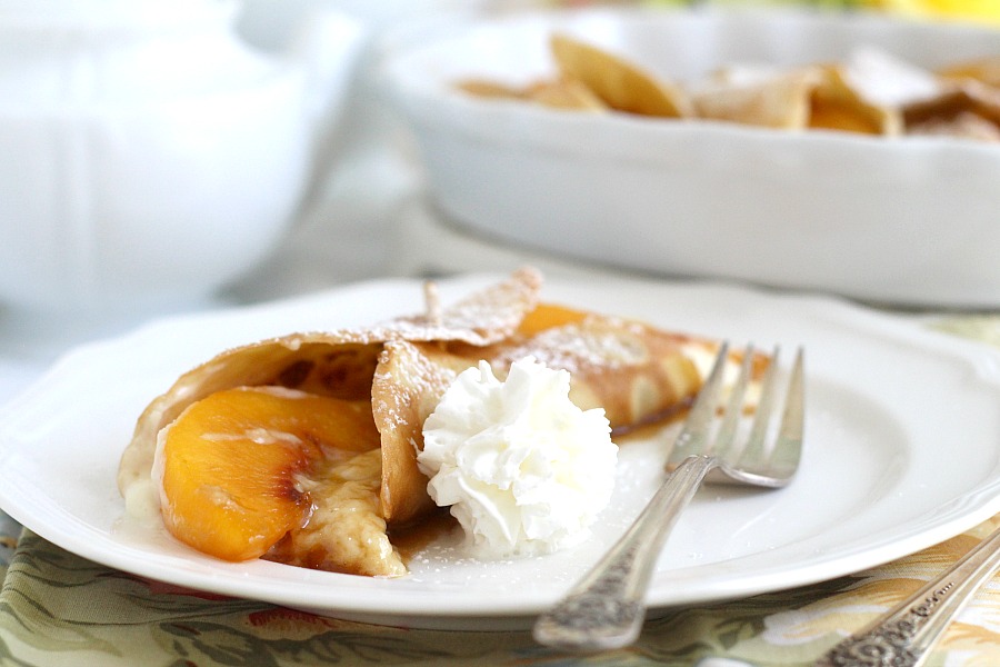 Peaches and Cream Cheese Crepes begins with a simple crepe, then filled with a sweetened cream cheese mixture, fresh sliced peaches, a sprinkling of brown sugar and a pat of butter that is then baked until warmed through. A dusting of confectioners' sugar and topped with whipped cream finishes this lovely dessert.