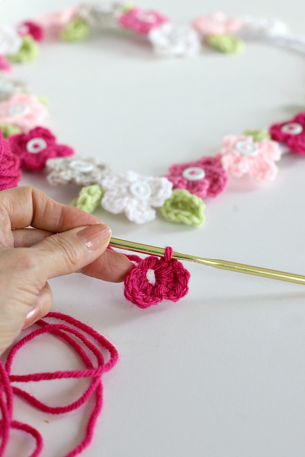 Quick, easy and perfectly pretty, this sweet crochet flower heart is cheerful, bright and a great craft for Valentine's Day. Easy pattern with step-by-step photos for heart, leaves and wreath construction.