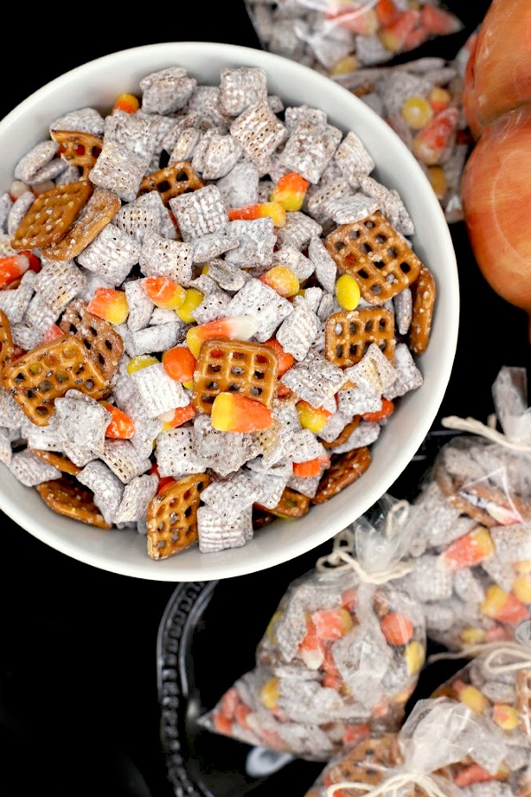 Crunchy, crispy, salty, sweet, Autumn Puppy Chow is easy to make with Chex Mix, chocolate, peanut butter and candy corn. Also called Muddy Buddy it is a perfect Halloween party treat! 