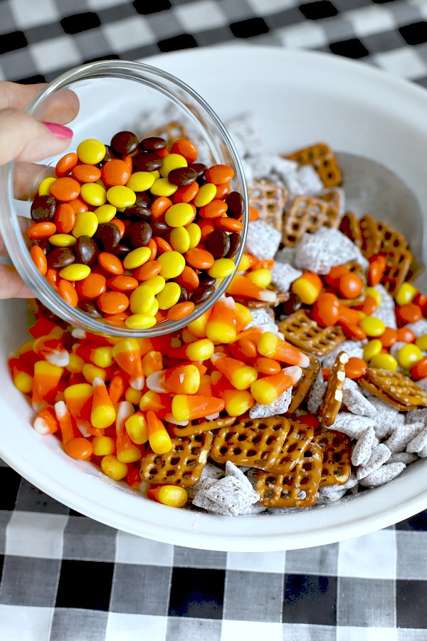 Easy to make, autumn puppy chow is a kid and adult favorite Halloween party snack. Chex mix, chocolate, peanut butter and candy corn tossed with confectioners sugar is a frightfully delicious concoction!