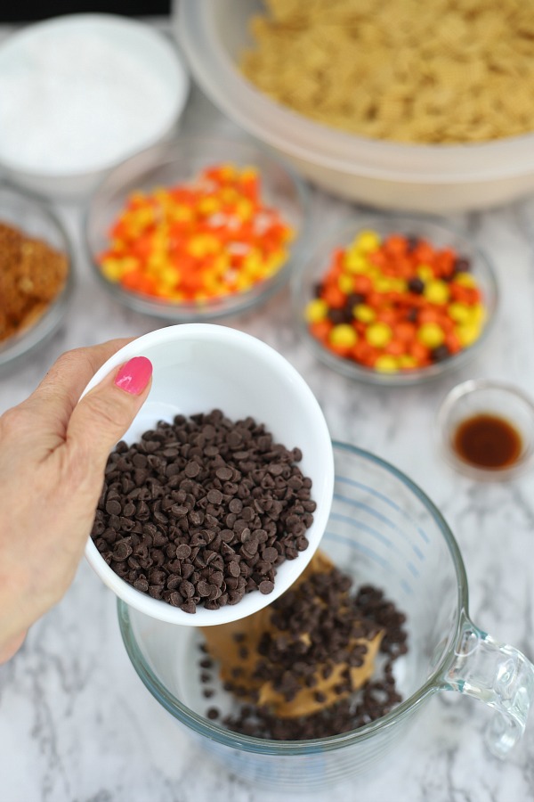 Easy to make, autumn puppy chow is a kid and adult favorite Halloween party snack. Chex mix, chocolate, peanut butter and candy corn tossed with confectioners sugar is a frightfully delicious concoction!