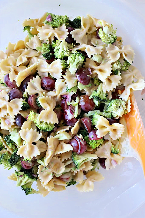 Easy recipe for broccoli grape pasta salad that is tasty, colorful and a perfect side dish or entrée. Tender bow tie pasta is tossed with a creamy, sweet and tangy dressing and topped with toasted pecans and crisp bacon.