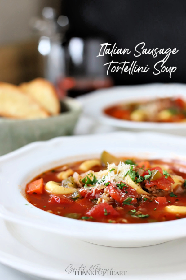 Hearty and so flavorful, this easy recipe for Italian sausage tortellini soup is a meal in a bowl. Elegant for entertaining or perfect for weeknight dinner with crusty bread. Tender veggies and pasta in tomato broth topped with parmesan will warm your soul and tummy.