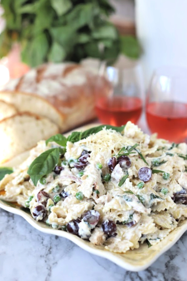Make a big bowlful of creamy chicken pasta salad for dinner, lunch, potluck or cookout side dish. Easy recipe full of chicken, Parmesan, grapes and veggies with a fresh burst of basil.