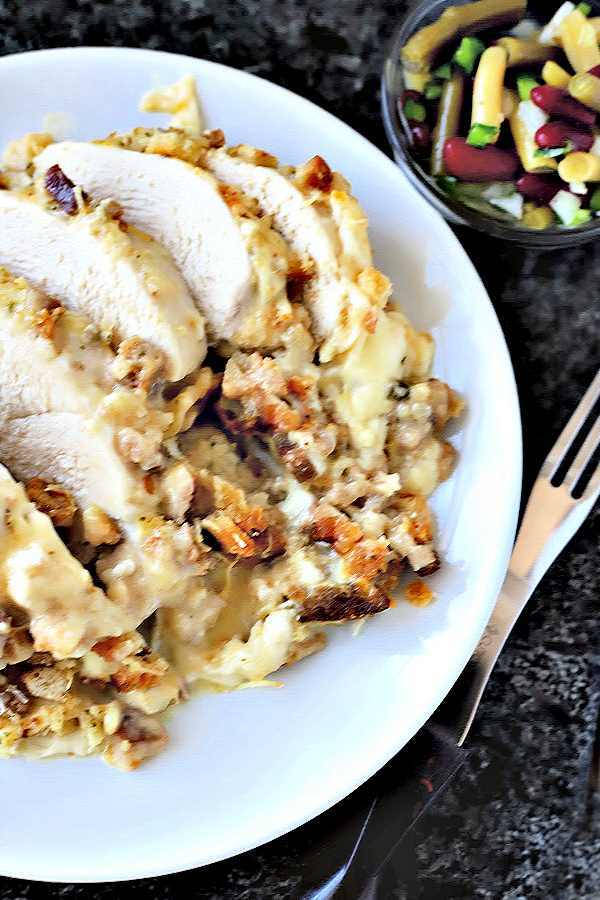 Cheesy Chicken & Stuffing is an easy recipe of baked chicken in a creamy sauce topped with stuffing and melted Swiss cheese. And best of all... it is a cinch to make! Perfect potluck casserole or kid-friendly weeknight dinner meal.