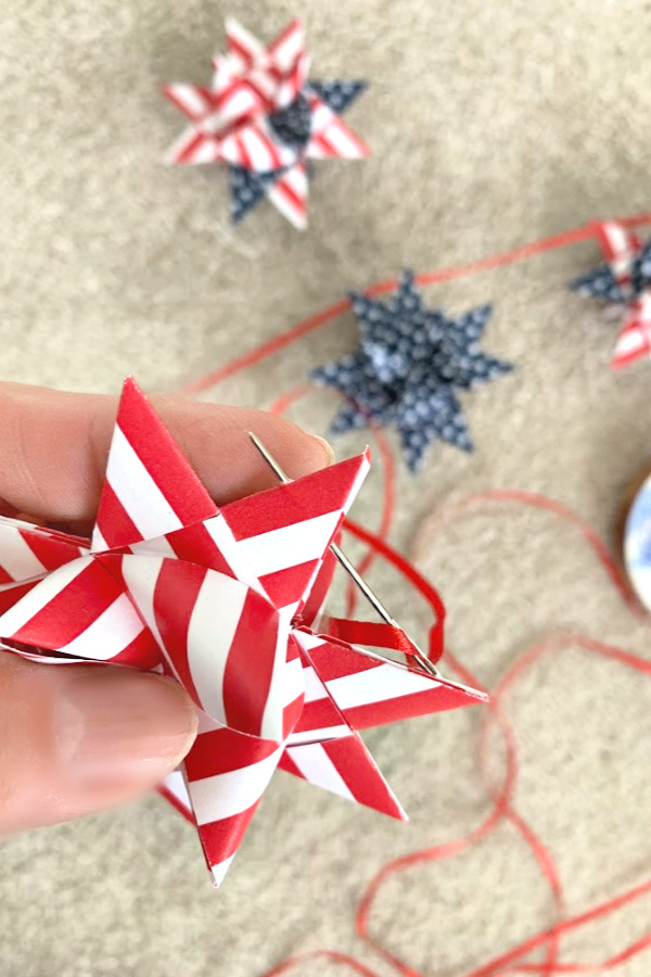 Easy step-by-step video tutorial how-to for patriotic paper stars perfect for 4th of July, Memorial Day or the military hero in your life. Made by folding and turning strips of paper creating a lovely 16-pointed, three dimensional ornament.