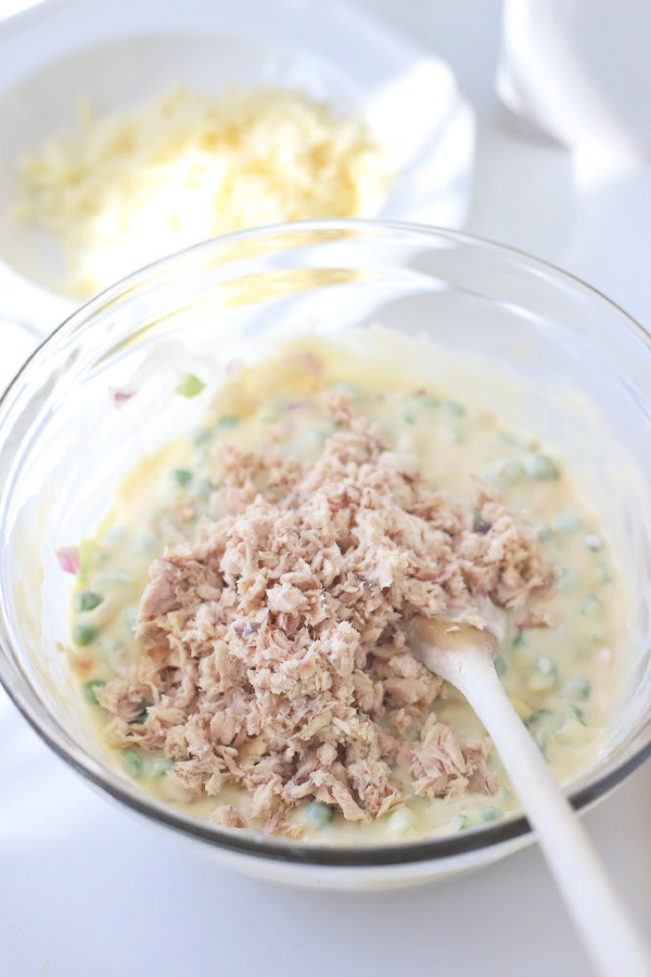 Classic creamy tuna noodle casserole with egg noodles is budget-friendly. Quick and easy recipe using cream of chicken soup, mayo and cheddar cheese.