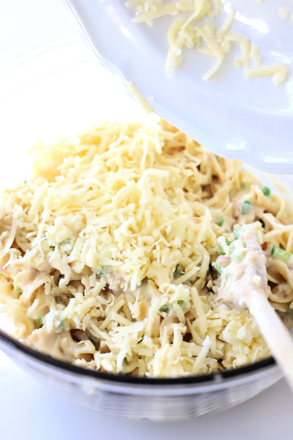 Classic creamy tuna noodle casserole with egg noodles is budget-friendly. Quick and easy recipe using cream of chicken soup, mayo and cheddar cheese.