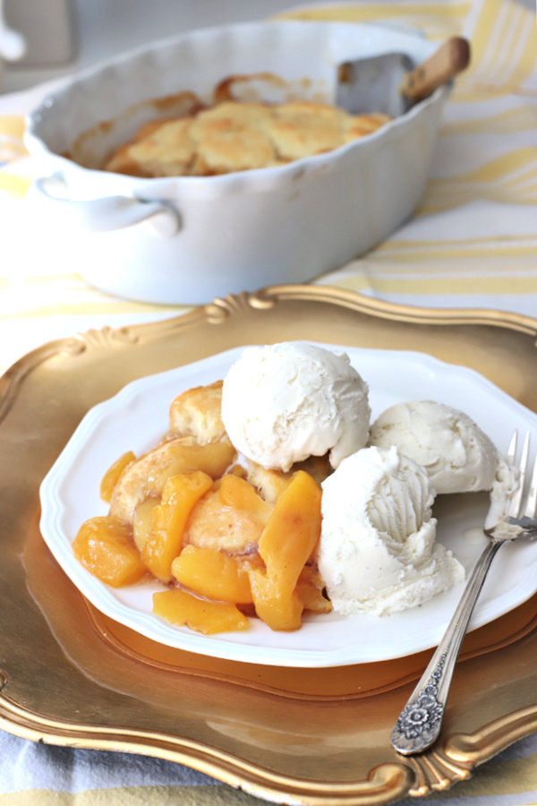 Homemade peach cobbler is a lightly sweet, shortbread-like cake over sweet, fresh peaches. This easy recipe, baked until hot and bubbly, is a perfect summer dessert topped with a scoop of ice cream or dollop of whipped cream.