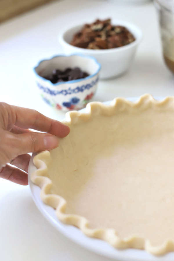 Preparing the crust for a chocolate pecan pie