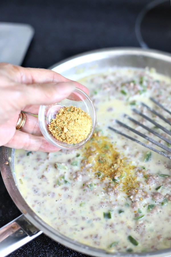 adding spices for country sausage gravy