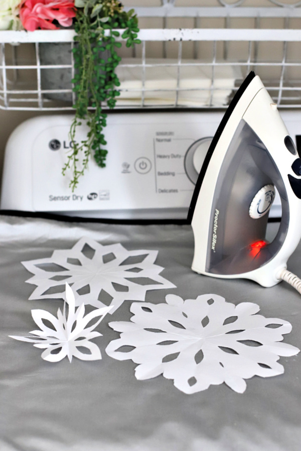 Use an iron to flatten the folds and wrinkles on paper snowflakes.