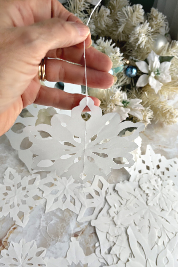 Add a string for hanging paper snowflakes.to paper snowflakes .