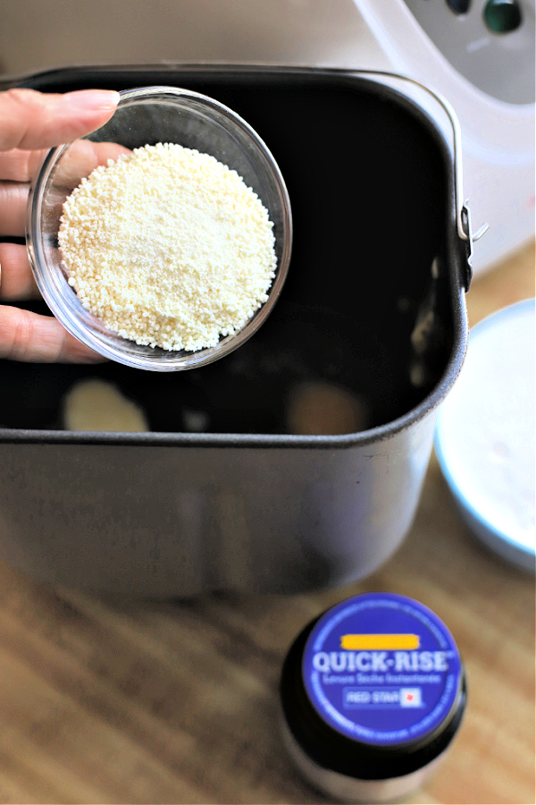 Adding dry powdered milk to a bread machine pan