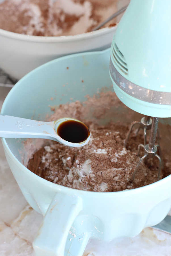 Adding vanilla to the fluffy chocolate frosting recipe for chocolate mocha cake.