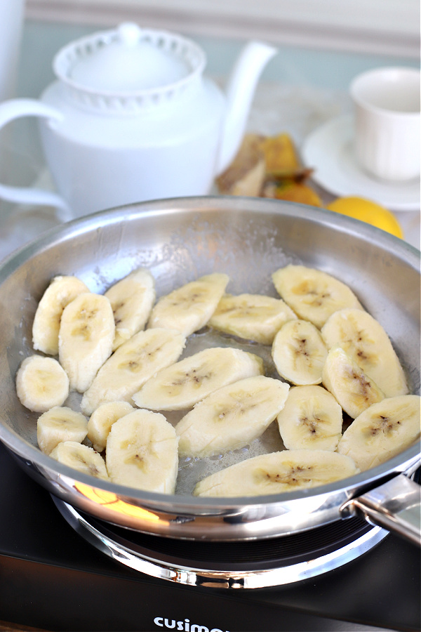Adding fresh bananas to skillet for making sautéed bananas.