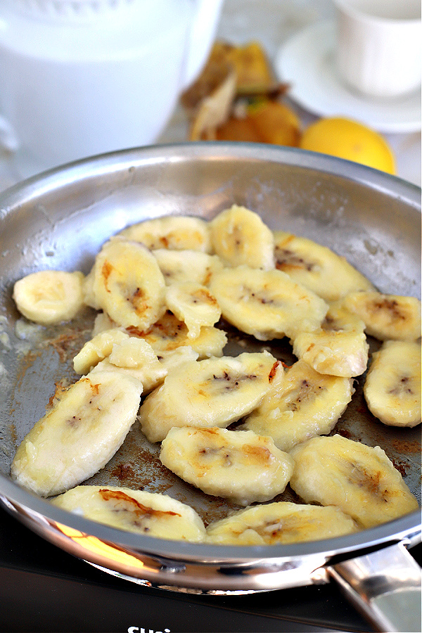 Frying bananas in skillet for sautéed bananas.