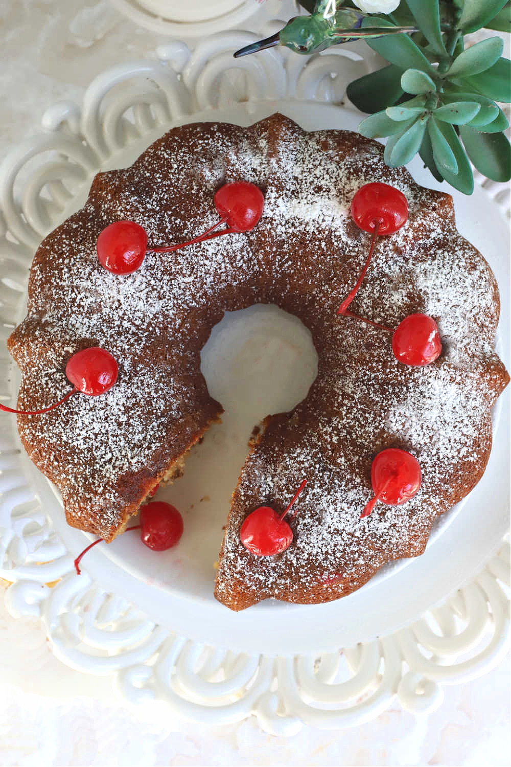 This Hummingbird cake is an easy recipe Bundt cake with pineapple, bananas, cherries, pecans and cinnamon beginning with a box mix. 